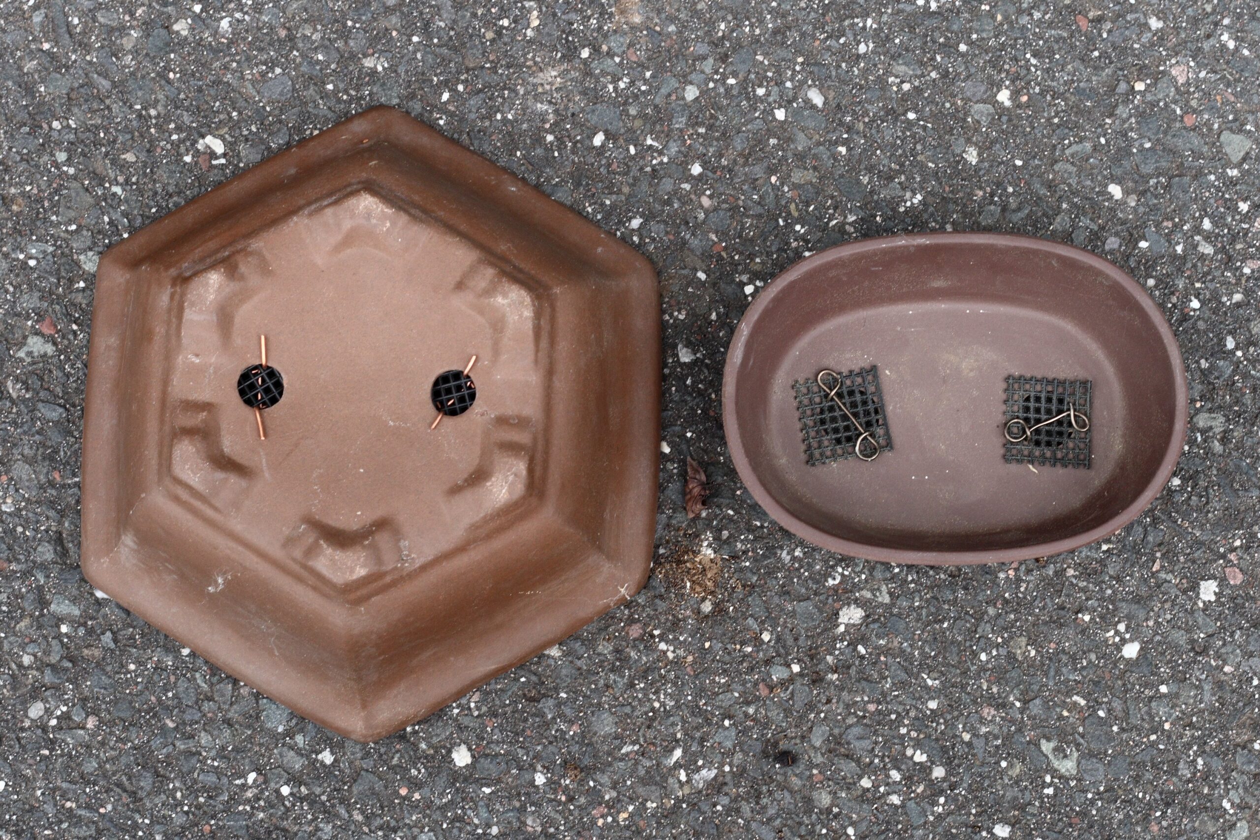 Bonsai pot bases showing drainage holes covered with mesh screens